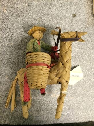 Doll: man w/baskets on donkey