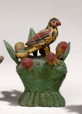 Figurine of parrot on basket of flowers