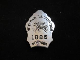 Badge on block in envelope: Veteran Association, 1885 NY